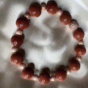 bracelet features large, polished goldstone beads
